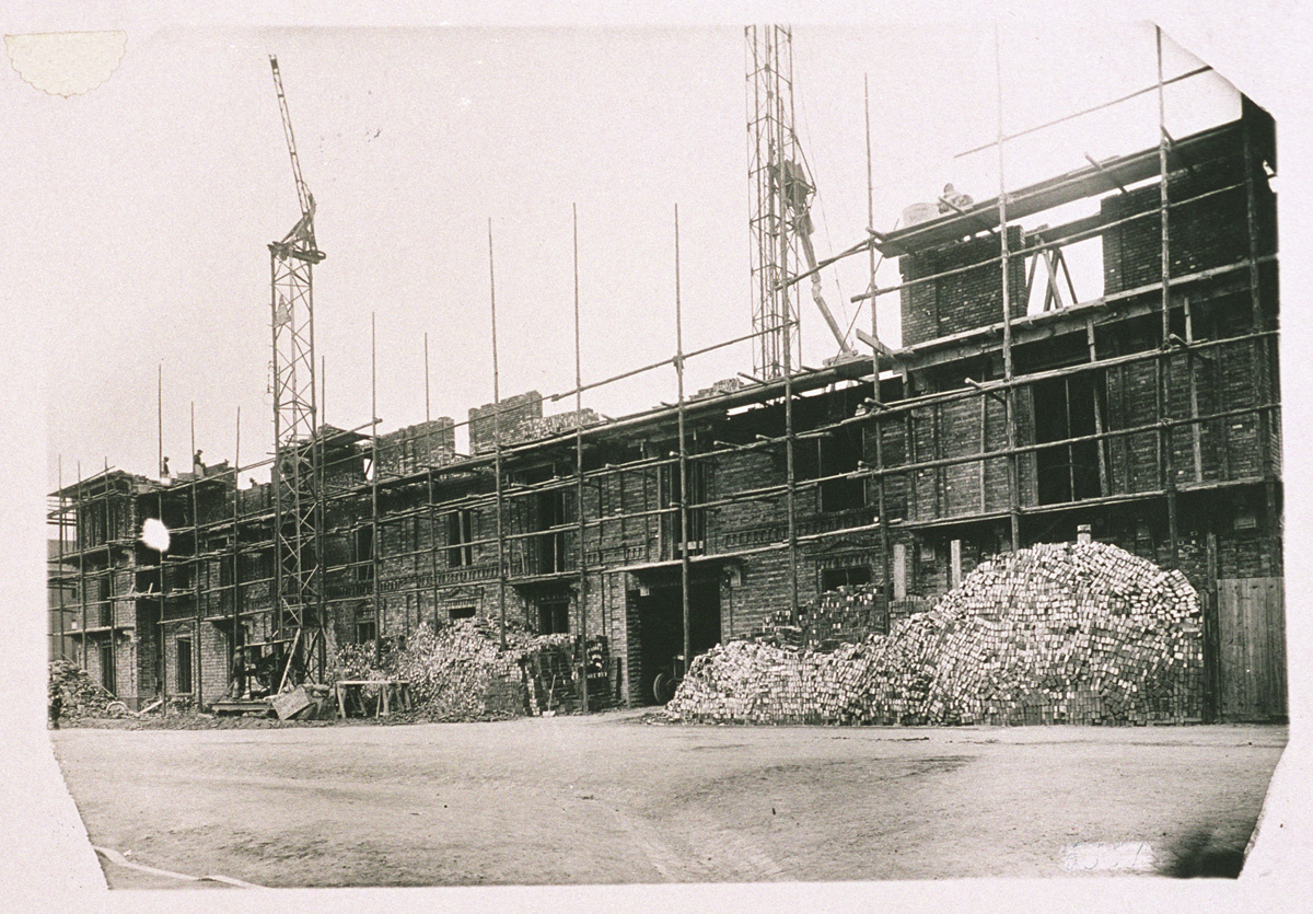 Devant la façade sud en reconstruction de l’aile gauche du Palais social du Fami