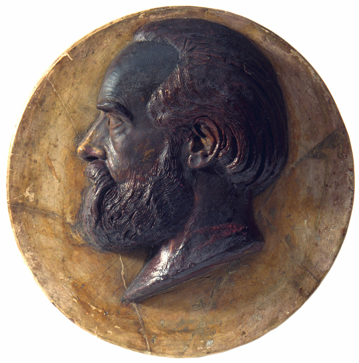 Le relief en cire en forme de médaillon représente la tête de Godin.