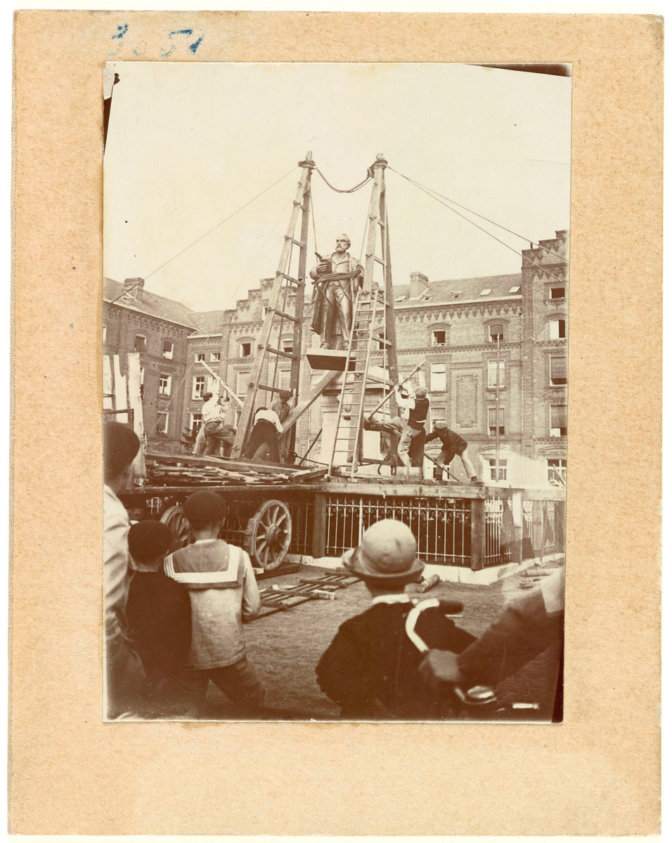 La photographie montre l'installation de la statue sur son piédestal