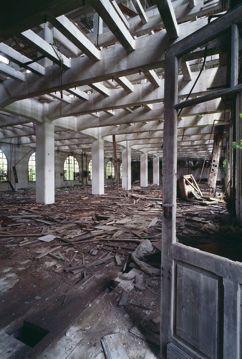 La photographie montre l'intérieur ruiné d'un bâtiment à structure de béton.