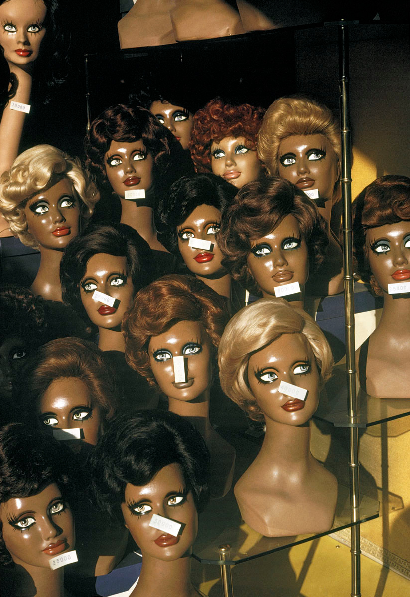 La photographie montre des têtes de mannequin féminins dans une vitrine.