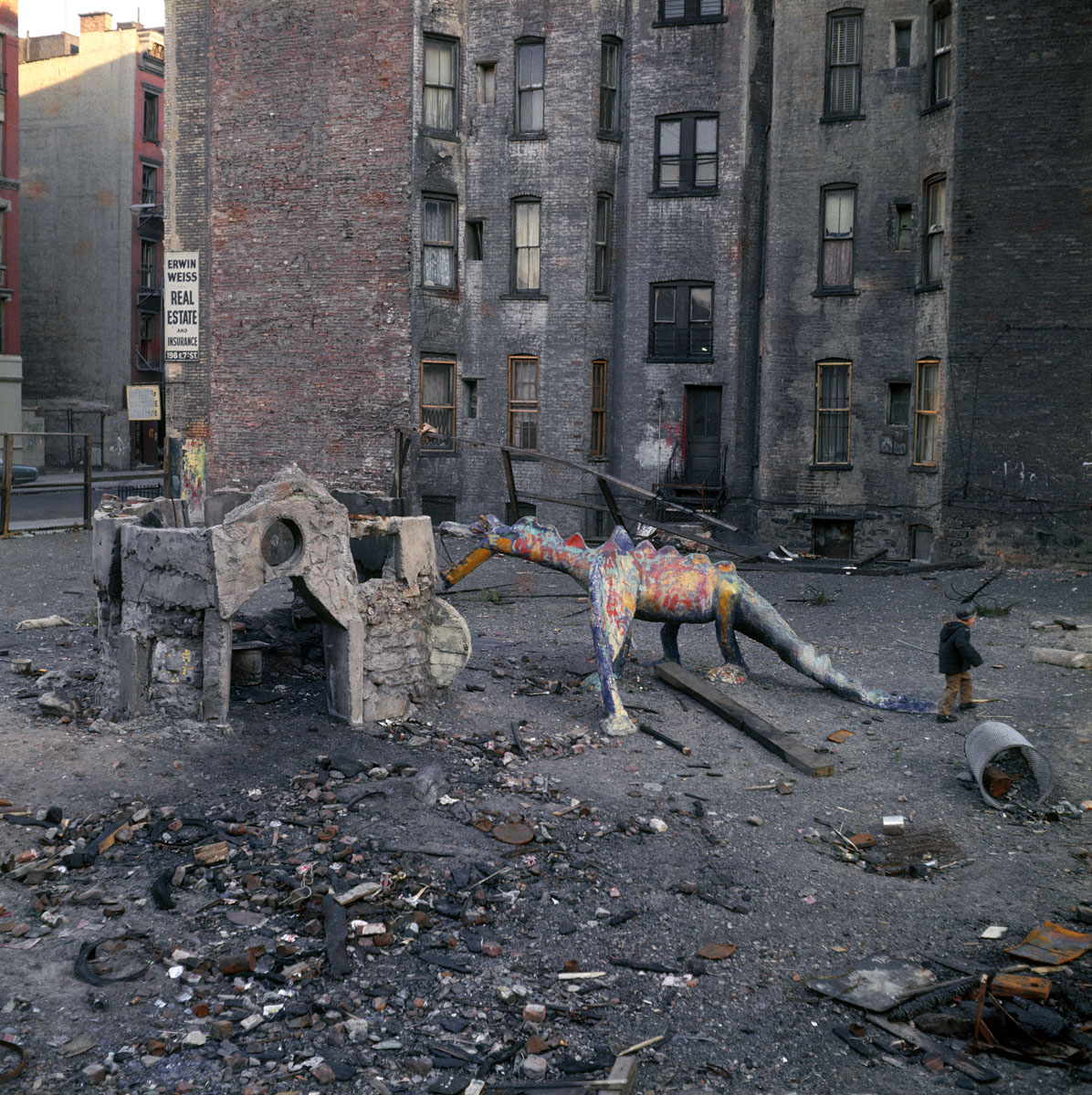 La photographie montre une zone urbaine abandonnée ornée de la sculpture d'un dr