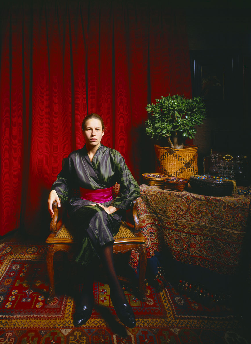 La photographie montre une jeune femme assise dans un intérieur.