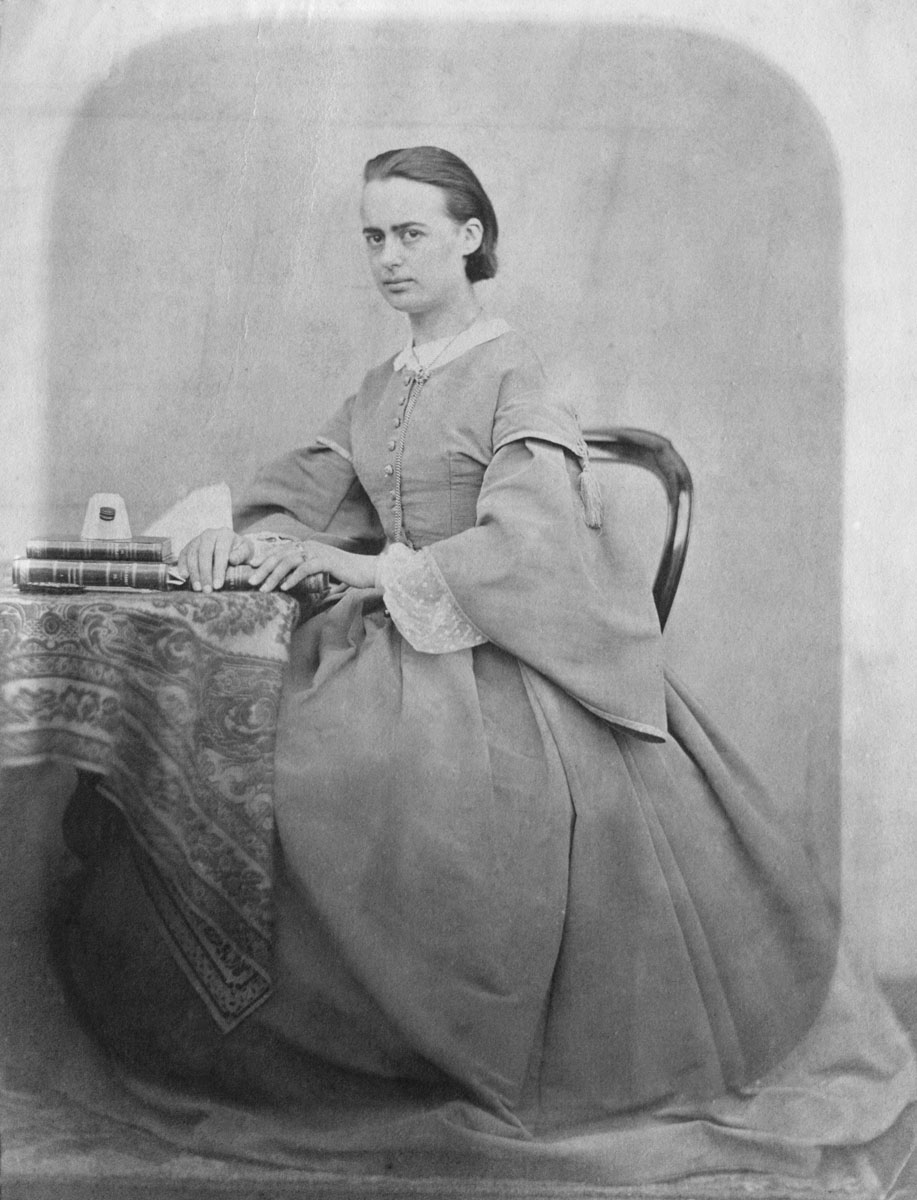 Portrait photographique de Marie Moret assise à une table