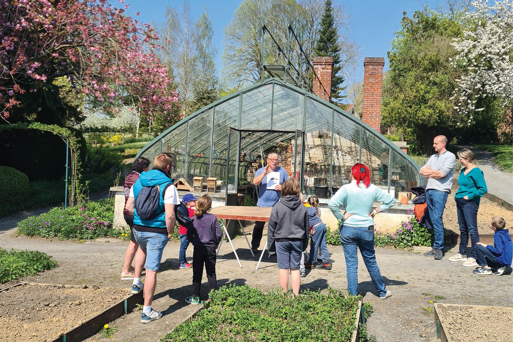 Visiteurs en famille écoutant les consignes du jardinier